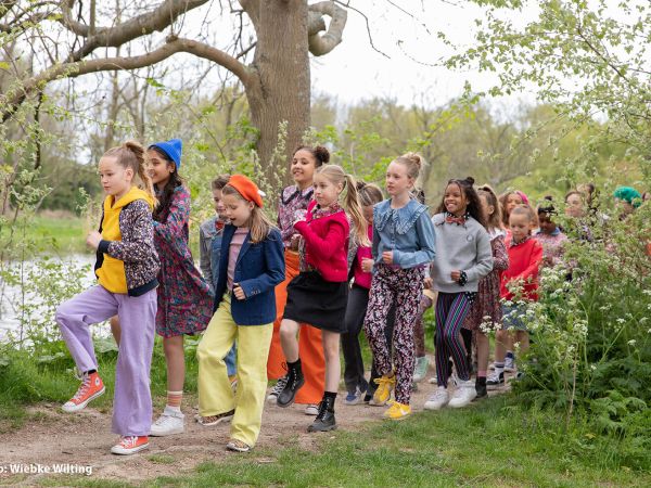 Kinderen wandelen vrolijk langs een vijver